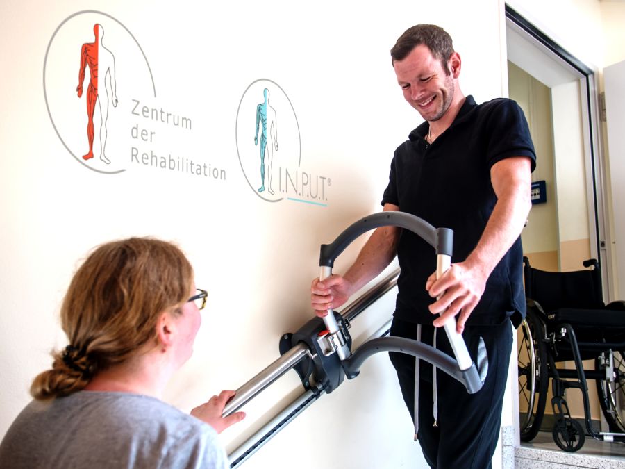 Patient mit einem inkompletten Querschnitt und Rückenmarksverletzungen trainiert das Treppensteigen mit dem Treppensteiggerät ASSISTEP während der Rehabilitation